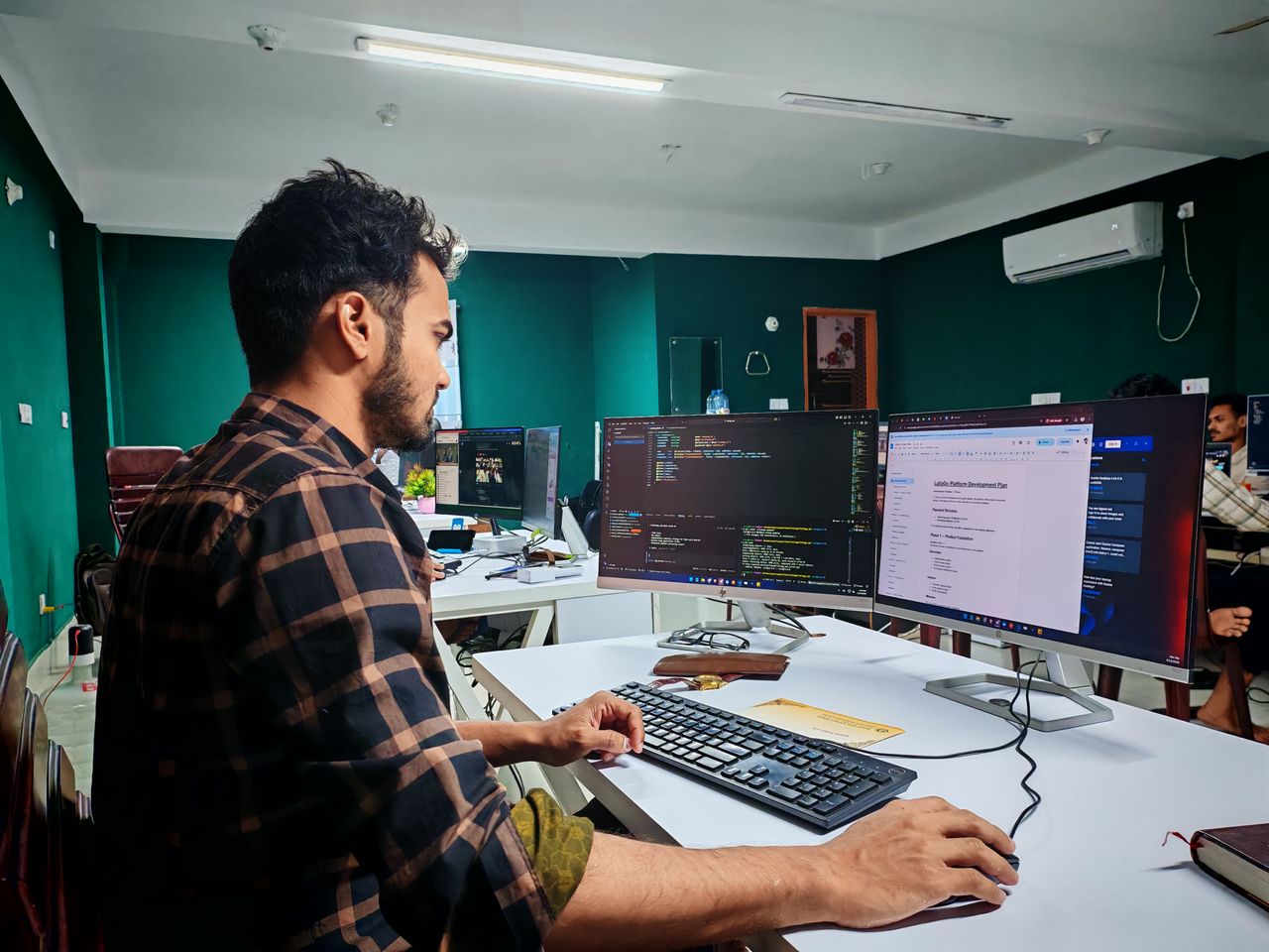 Mastering the First Impression: Your intriguing post title goes here Software developer coding on dual monitors in a well-lit modern office, focused and engaged.